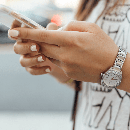 woman with white nails using phone